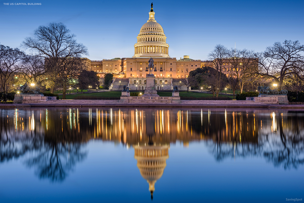 Picture of the US Capitol building in the evening with lights on, reflecting on the water in front of it